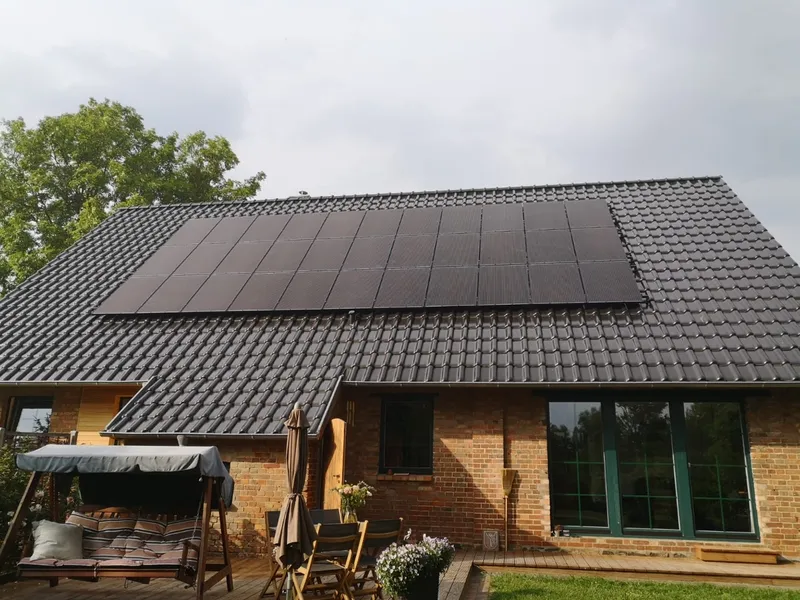 Bungalow mit schwarzen Photovoltaikmodulen auf dem Dach