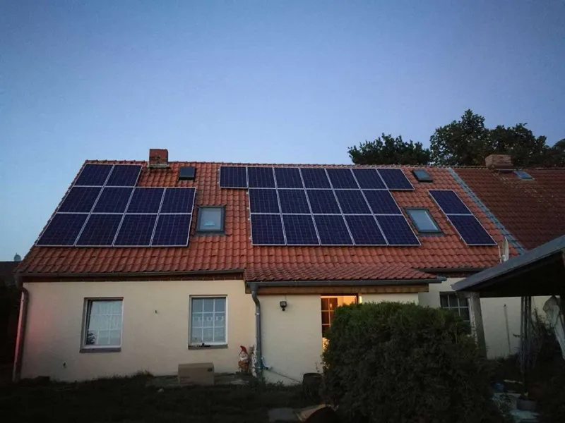 Einfamilienhaus mit roten Ziegeln und Photovoltaikmodulen