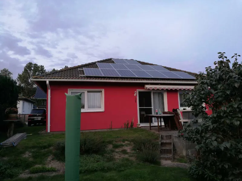 Wohnhaus mit Photovoltaikanlage im Garten gesehen
